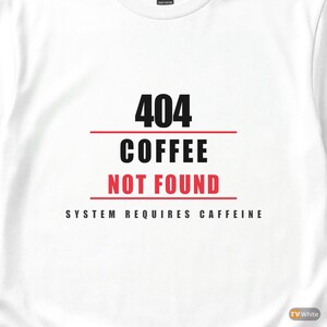 Może przedstawiać: Biała koszulka z napisem "404 COFFEE NOT FOUND" w kolorze czarnym i czerwonym. Koszulka ma również napis "SYSTEM REQUIRES CAFFEINE" w kolorze czarnym. Koszulka jest z krótkim rękawem.