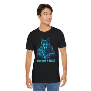 Op de afbeelding: Zwart t-shirt met een neon wolf afbeelding die een laptop gebruikt. De wolf en de laptop hebben blauwe en paarse tinten. De tekst "CODE LIKE A BEAST" staat eronder.