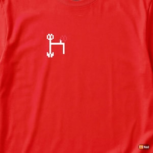 May include: A vibrant red t-shirt with a white, pixelated graphic of scissors. The design is simple and bold, likely printed on a comfortable fabric. This t-shirt is suitable for everyday wear.