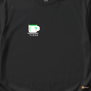 Könnte beinhalten: Schwarzes T-Shirt mit einer Grafik einer grün-weißen Kaffeetasse mit Dampf, einem Fragezeichen und dem Wort "TOKEN" darunter. Das Design ist mittig auf dem Shirt platziert.
