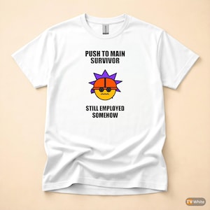Puede incluir: Camiseta blanca con un gráfico que presenta una carita sonriente amarilla con un casco naranja y un tocado en forma de estrella púrpura. El texto dice "PUSH TO MAIN SURVIVOR" encima del gráfico y "STILL EMPLOYED SOMEHOW" debajo.