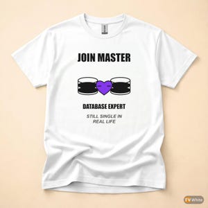 Op de afbeelding: Een wit t-shirt met korte mouwen voorzien van de zwarte tekst JOIN MASTER, een afbeelding van twee zwarte databasecilinders verbonden door een paars hart, en de zwarte tekst DATABASE EXPERT gevolgd door STILL SINGLE IN REAL LIFE.