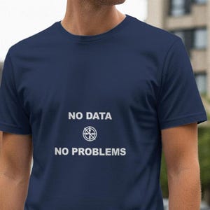 May include: Navy blue t-shirt with the text "NO DATA NO PROBLEMS" in white. The text is centered on the front of the shirt, above a circular graphic. The shirt has short sleeves and a crew neck.