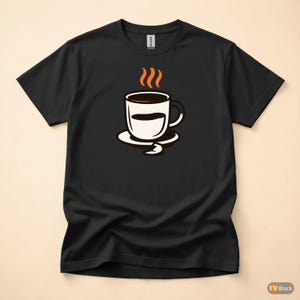 Op de afbeelding: Zwart T-shirt met een koffiekopje. Het ontwerp toont een wit koffiekopje met een bruin interieur en stoom die uit de bovenkant opstijgt. De beker staat op een witte schotel met een gebogen ontwerp.
