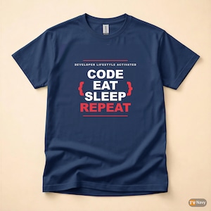 Puede incluir: Camiseta azul marino con el texto "DEVELOPER LIFESTYLE ACTIVATED" encima de "CODE EAT SLEEP REPEAT" en blanco y rojo. La camiseta tiene cuello redondo y mangas cortas.