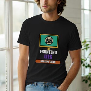Op de afbeelding: Zwart T-shirt met de tekst "FRONTEND LIES BACKEND CRIES". Het shirt heeft een afbeelding van een computerscherm met een huilende emoji. Het ontwerp is in wit, paars, oranje en groen.