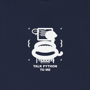 Op de afbeelding: Marineblauw T-shirt met een witte afbeelding van een slang die zich om een computerscherm wikkelt en de tekst "TALK PYTHON TO ME". Het ontwerp bevat tekstballonnen en golvende lijnen. Het T-shirt is gemaakt van zacht materiaal.