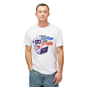 Op de afbeelding: Wit T-shirt met een cartoonrobot die een koffiekopje en een laptop vasthoudt. De tekst "I turn coffee into code" is gedrukt in blauw en rood. De robot heeft een witte body, zwarte ogen en een rood hart. Het laptopscherm toont code.