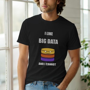 Puede incluir: Camiseta negra con el texto "I LIKE BIG DATA AND I CANNOT" sobre un gráfico de dibujos animados de discos de almacenamiento de datos apilados en amarillo, naranja y morado. La camiseta es de cuello redondo.
