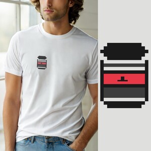 Może przedstawiać: Biały t-shirt z krótkim rękawem z małą grafiką w stylu pixel art na lewej piersi. Grafika przedstawia stylizowany pojemnik z czarną pokrywką, poziomym czerwonym paskiem z małą czarną ikoną w kształcie litery T oraz ciemnoszarą podstawą.