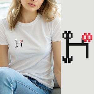 Könnte beinhalten: Ein weißes T-Shirt mit kurzen Ärmeln und einer kleinen, verpixelten Grafik auf der Brust. Das Design besteht aus einer schwarzen, H-förmigen Struktur mit einem roten, verpixelten quadratischen Element auf der oberen rechten Seite des Rahmens.
