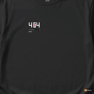 May include: Black t-shirt with a white pixelated "404" graphic, a horizontal bar, and three dots. A red plus sign is to the right of the bar. The shirt is made of heavy cotton.