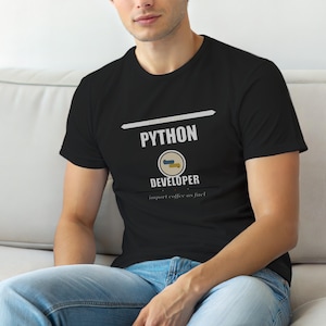 Puede incluir: Una camiseta negra de manga corta con el texto blanco PYTHON DEVELOPER, un icono circular con formas azules y amarillas, y el texto import coffee as fuel, con una línea horizontal sobre el texto y una línea más pequeña debajo del mismo.