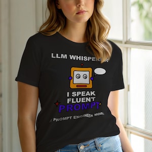以下が含まれることがあります： 「LLM Whisperer」と「I Speak Fluent Prompt」の文字が入った黒いTシャツ。中央には吹き出しを持った漫画のロボットが描かれています。「Prompt Engineer Mode」の文字が下部にあります。