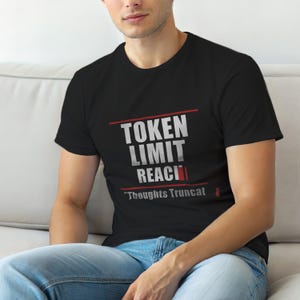 Peut inclure: T-shirt noir avec l'inscription "TOKEN LIMIT REACHED" en blanc et rouge. La phrase "Thoughts Truncated" est en dessous du texte principal. Le t-shirt est porté par une personne.