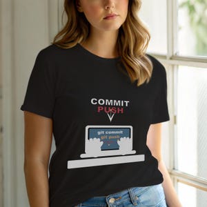 May include: Black t-shirt with the words "COMMIT PUSH" above a laptop graphic. The laptop screen displays "git commit git push". The design features a white laptop outline with hands and a blue screen.