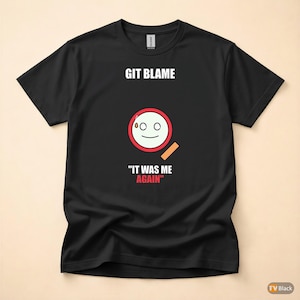 Op de afbeelding: Zwart T-shirt met de tekst "GIT BLAME" boven een cartoongezicht in een rode cirkel. Onder de cirkel staat de tekst "IT WAS ME AGAIN". Het ontwerp is gedrukt op een zwart Gildan T-shirt.