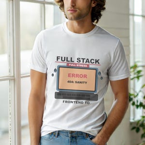 Puede incluir: Camiseta blanca con un gráfico de una pantalla de ordenador que muestra un mensaje de error. El texto de la camiseta dice "FULL STACK" encima de la pantalla y "FRONTEND TO" debajo. La pantalla muestra "ERROR 404: SANITY".