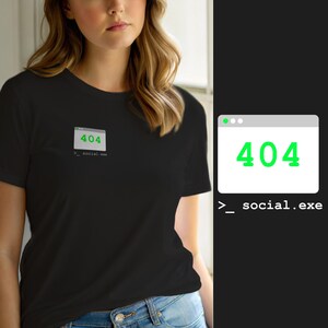Puede incluir: Una camiseta negra de manga corta con un pequeño gráfico en el pecho. El gráfico muestra una ventana de computadora blanca con el texto verde 404 y el texto blanco >_ social.exe impreso directamente debajo del icono.