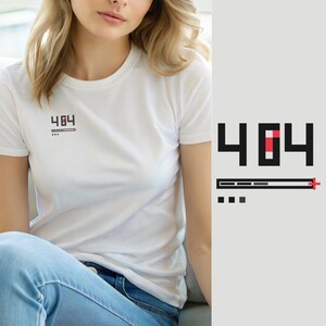 Op de afbeelding: Een wit T-shirt met korte mouwen en een kleine afbeelding op de linkerborst. De afbeelding toont de zwarte tekst 404 met een rood vierkant in de nul, een horizontale laadbalk met een rood plusteken en drie kleine zwarte vierkantjes eronder.