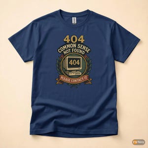 Könnte beinhalten: Ein marineblaues T-Shirt mit einem Grafikdruck eines alten Computermonitors mit der Aufschrift 404, umgeben von einem Lorbeerkranz. Der Text lautet 404 COMMON SENSE NOT FOUND und PLEASE CONTACT IT in einer kräftigen, retro-inspirierten Schriftart.