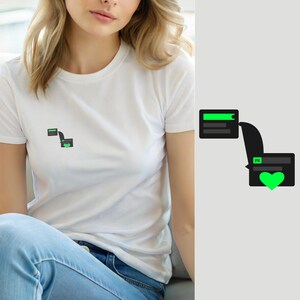 Peut inclure: Un t-shirt blanc à manches courtes avec un petit motif sur la poitrine. Le motif représente deux bulles de discussion rectangulaires gris foncé reliées par une ligne, avec une barre de progression vert vif, les lettres FK et un cœur vert.