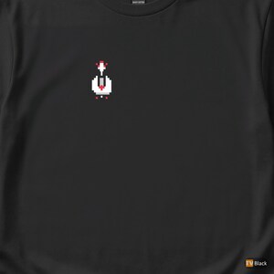 May include: Black t-shirt with a pixelated graphic of a white and red design on the upper left chest. The shirt is made of heavy cotton. The lower right corner of the shirt has the text "TV Black".