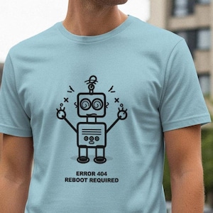 May include: A pale blue t-shirt with a black and white robot graphic and the words "ERROR 404 REBOOT REQUIRED". The robot design has a square head, circular eyes, and outstretched arms.