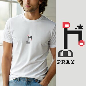 Puede incluir: Una camiseta blanca de manga corta con un pequeño gráfico de pixel art centrado que muestra un grifo negro con detalles en rojo y una pequeña estrella. Debajo del gráfico, la palabra PRAY está impresa en una fuente negra pixelada.