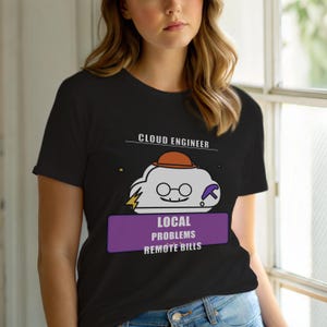 Op de afbeelding: Zwart T-shirt met een cartoon wolkfiguur met een hoed en bril, een bliksemschicht en een pikhouweel. De tekst "CLOUD ENGINEER" staat boven de wolk en "LOCAL PROBLEMS REMOTE BILLS" staat eronder.