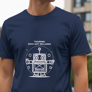 Op de afbeelding: Marineblauw t-shirt met een witte robotafbeelding en de tekst "TRAINING DATA NOT INCLUDED". Het robotontwerp heeft een witte omtrek en een cirkelvormige rand. Het shirt is gemaakt van zacht materiaal.