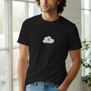 Op de afbeelding: Zwart T-shirt met ronde hals en een witte wolk met groene bliksem graphic, en de tekst "CLOUD ENG". Het T-shirt is gemaakt van een zacht materiaal.
