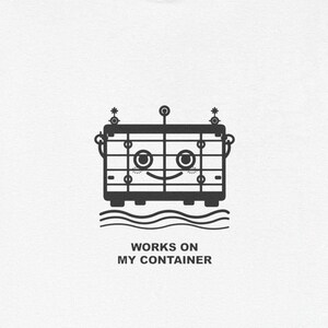 May include: White t-shirt featuring a black and white graphic of a container with a smiling face, set above wavy lines. The text "WORKS ON MY CONTAINER" is printed below the graphic. The shirt has short sleeves and a crew neck.