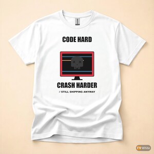Può includere: T-shirt bianca con la scritta "CODE HARD" sopra una grafica di monitor di computer con un teschio e ossa incrociate, e la scritta "CRASH HARDER" sotto. La frase "// STILL SHIPPING ANYWAY" è stampata sotto.