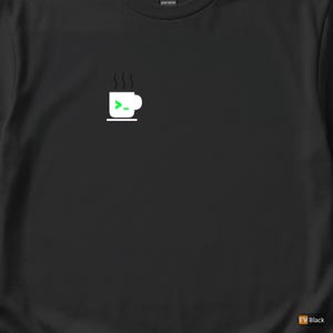 Op de afbeelding: Zwart T-shirt met een witte afbeelding van een koffiekopje, stoom en een groen commandopromptsymbool. Het ontwerp is gecentreerd. Gemaakt van zwaar katoen. Eenvoudig, modern ontwerp.