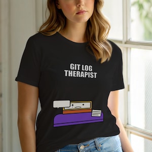 May include: Black t-shirt featuring the white text "GIT LOG THERAPIST". The design includes a graphic of a computer screen with a sad face, a speech bubble, and a purple desk.