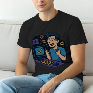 Puede incluir: Camiseta negra con una ilustración de dibujos animados de un programador celebrando el éxito. El diseño incluye una computadora, una marca de verificación, engranajes y símbolos de código. El programador lleva gafas y una camiseta azul. Tema: tecnología y codificación.
