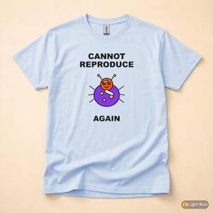 Op de afbeelding: Lichtblauw T-shirt met de tekst "CANNOT REPRODUCE AGAIN" boven een cartoonillustratie van een paarse kever met een oranje gezicht en antennes. De kever heeft een witte rechthoek op zijn lichaam.