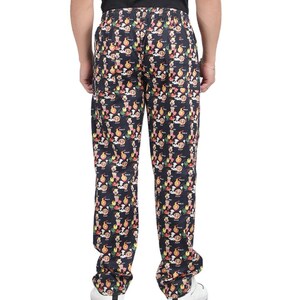 May include: Black trousers with an elasticated waistband featuring an all-over print of colourful food items including pizza slices, popcorn, and chef hats. The trousers have a straight-leg cut and are shown from the back, displaying the repeating pattern.