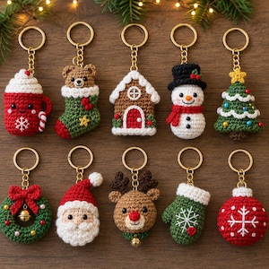 May include: A collection of ten crocheted Christmas keychains featuring a red mug, a bear in a stocking, a gingerbread house, a snowman, a tree, a wreath, Santa Claus, a reindeer, a green mitten, and a red ornament, all with gold metal rings.