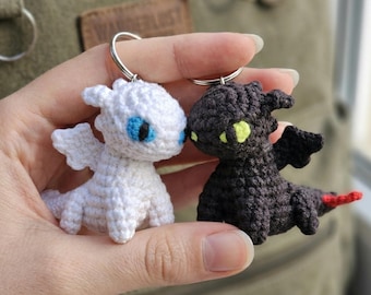 Mini peluche a forma di drago bianco e nero all'uncinetto, ispirato a Furia Buia e Furia Chiara.