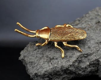 Figura de cucaracha de latón antiguo en miniatura con detalles de filigrana y acabado en oro envejecido.