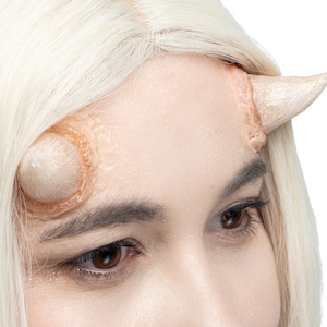 Puede incluir: Una taza de cerámica blanca con un asa negra y el texto "But First, Coffee" en negro, con una fuente de estilo manuscrito. La taza está sobre una superficie blanca.