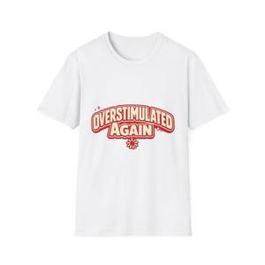 Può includere: T-shirt bianca con la scritta "OVERSTIMULATED AGAIN" in rosso, in stile retrò. Il design include una piccola grafica floreale sotto il testo. Un capo casual per l'uso quotidiano.