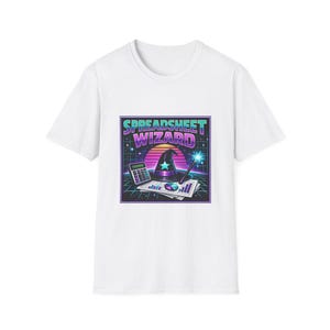 Puede incluir: Camiseta blanca con un gráfico colorido que dice "SPREADSHEET WIZARD". El diseño incorpora un sombrero de mago, una calculadora y una varita, sobre un fondo de puesta de sol retro. Esta camiseta es una prenda casual.