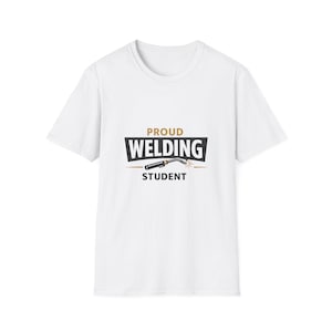 Può includere: T-shirt bianca con una grafica che recita "PROUD WELDING STUDENT". Il design presenta una torcia per saldatura in nero e oro. Il testo è in grassetto, con un carattere sans-serif.