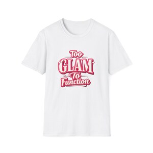 May include: White t-shirt with the text "Too Glam To Function" in a pink and red retro font. The shirt has a crew neck and short sleeves. The text is centered on the front of the shirt.