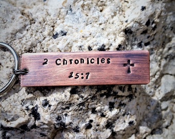 May include: A copper-colored keychain with the text "2 Chronicles 15:7" and a small cross engraved on it.