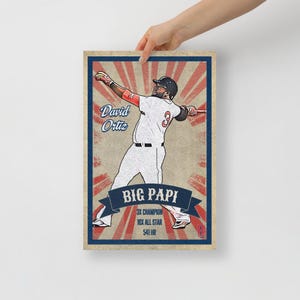 May include: A framed baseball art print featuring a stylized illustration of David Ortiz in a batting pose. The print has a vintage design with red and blue accents, and includes the text "David Ortiz" and "Big Papi". Additional text reads "3X Champion, 10X All Star, 541 HR".