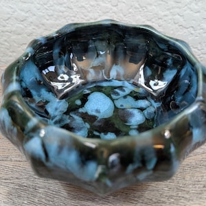 May include: A white ceramic mug with a black handle and the text "But First, Coffee" in a handwritten style. The mug is on a white surface. The mug is approximately 4 inches tall.